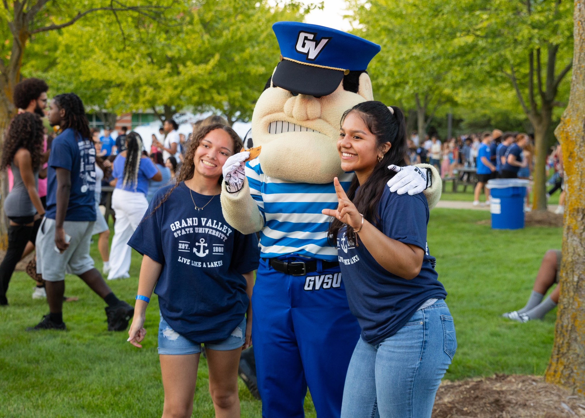 a group of female presenting students posing with Louie the Laker